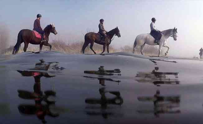 Uluabat Gölü'nde dizlerine kadar suya giren atların sırtında 'safari' keyfi