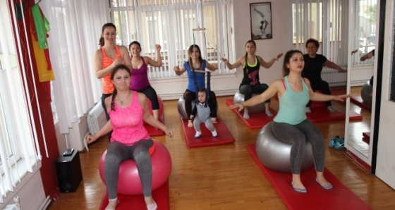 Bebeğiyle birlikte pilates eğitimi veriyor