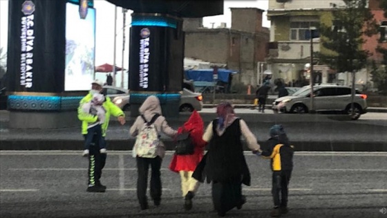 Diyarbakır'da doluya yakalanan anne ve çocukları trafik polisinin yardımıyla yolun karşısına geçti