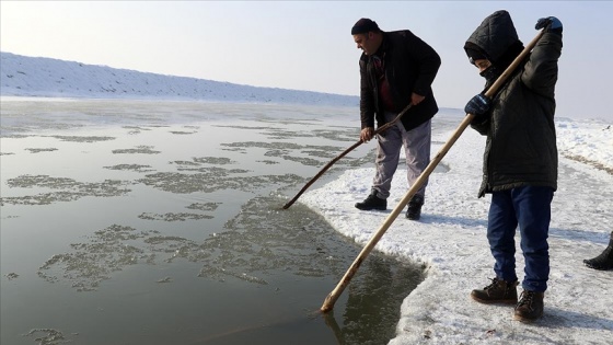 Ekmek parası için dondurucu soğuğa rağmen nehirdeki buzları kırıp balık avlıyorlar