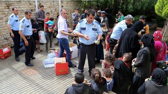 Göçmenlere polis giyecek ve yiyecek verdi