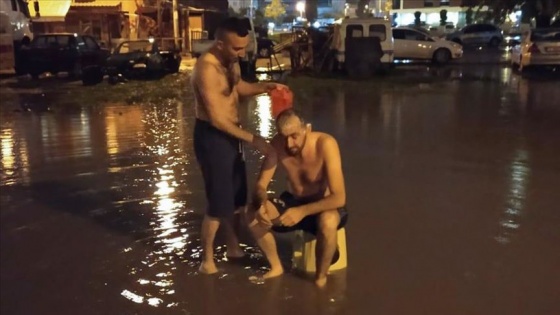 İzmir'de su kesintisine dikkati çekmek için yağmur suyuyla sokakta yıkandılar