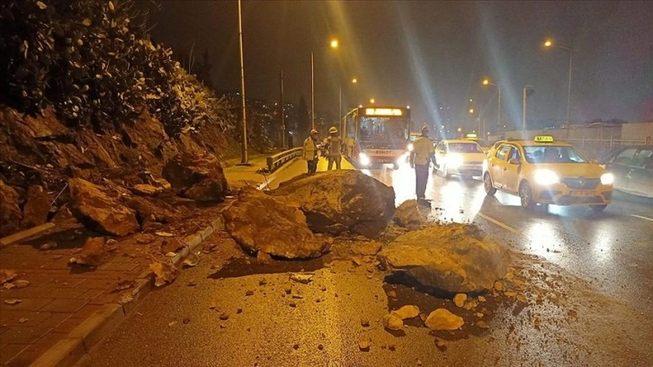 İzmir'de yağış nedeniyle koparak yola düşen kaya parçaları seyir halindeki otomobile zarar verdi