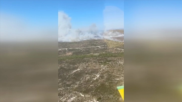 İzmir'in Çeşme ilçesinde ormanlık alanda çıkan yangına müdahale ediliyor