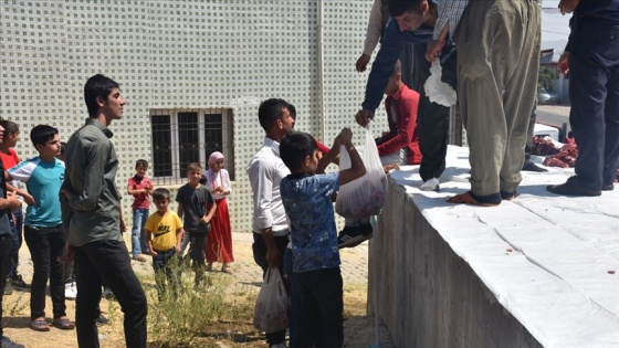 Kurban etini köy meydanında bölüşüyorlar