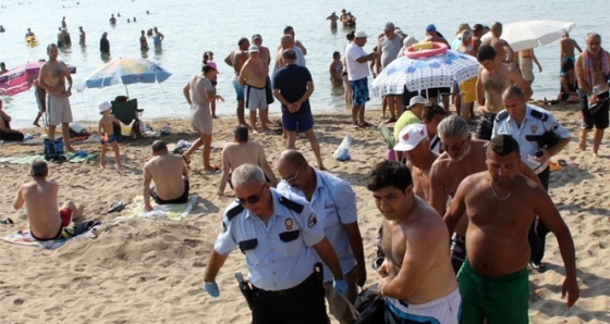 Plajdakiler kıyıdaki cesede aldırmaksızın yüzdü