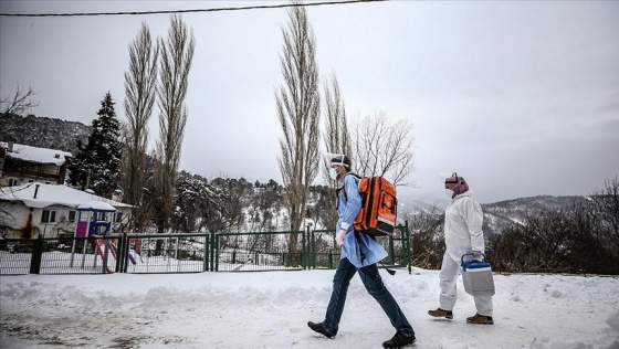 Uludağ'ın eteklerindeki karlı yolları aşıp hastaneye gidemeyen vatandaşları aşılıyorlar