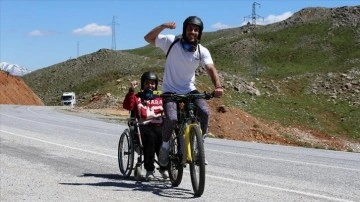 Bisikletine monte ettiği tekerlekli sandalyeyle engelli komşusunun tur hayalini gerçekleştirdi