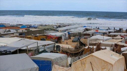 Gazze'de İsrail saldırılarından kaçarak sahile sığınan Filistinlilerin çadırlarını deniz suyu b