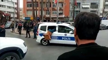 Gözaltına alınan zanlının polis aracının camından kaçmaya çalışması kameraya yansıdı