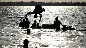 Kavurucu sıcakla boğuşan Irak'ta halk serinlemek için çareyi hastalık saçan nehirlerde buluyor